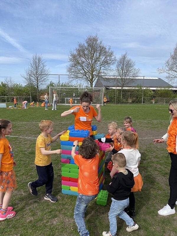 Kinderen bouwen toren van grote legoblokken